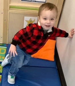 Toddler leaning against a wall